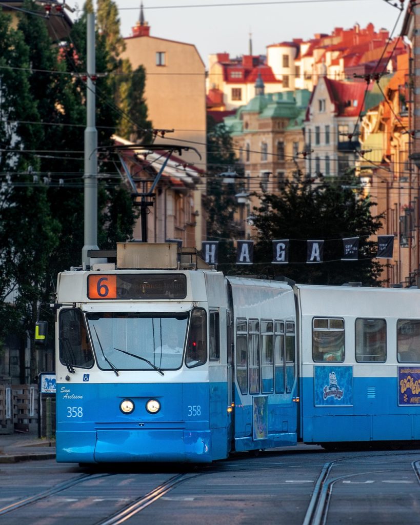Tram bleu circulant dans le quartier historique de Haga à Göteborg, entouré d’immeubles anciens.