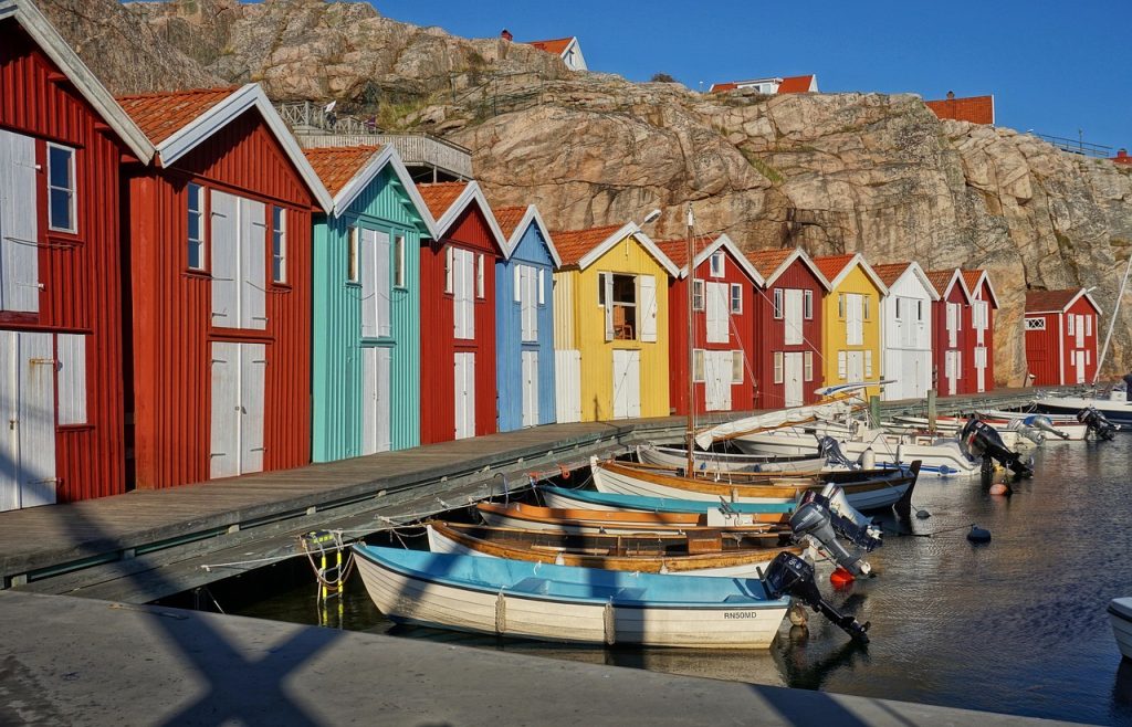 Cabanes de pêcheurs colorées à Smögen en Suède, sur le littoral du Bohuslän, avec bateaux amarrés au port.
